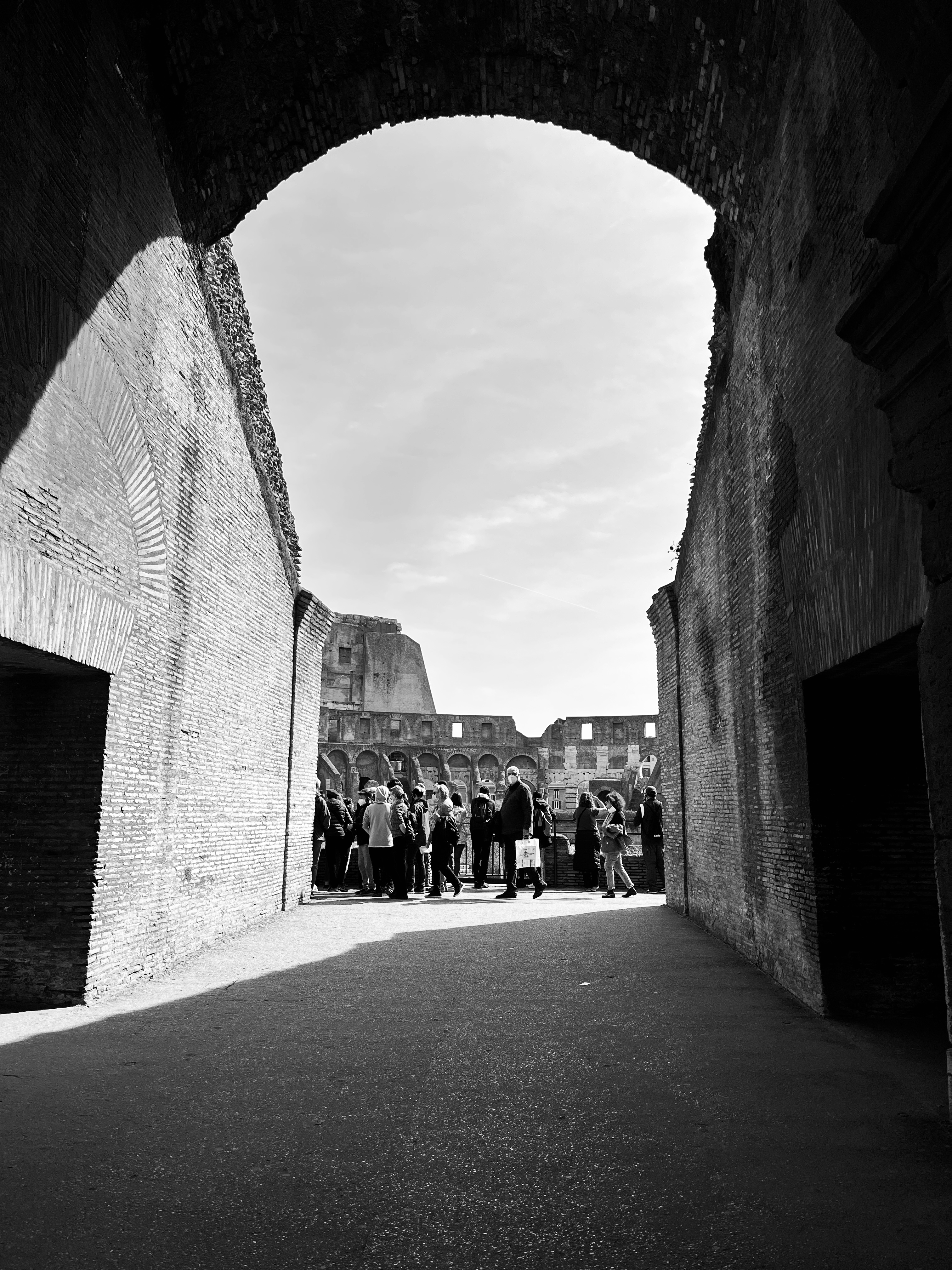 Fekete-fehér fénykép a Colosseumban nézelődő túristákról